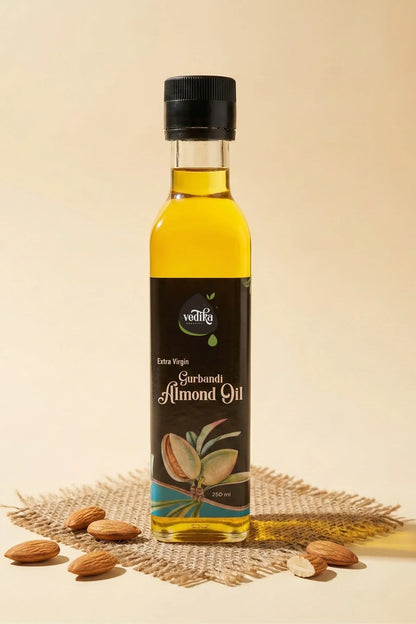 Bottle of almond oil with almonds on a textured surface